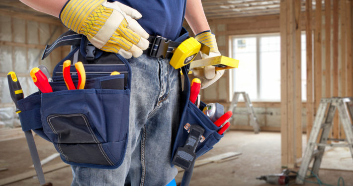 Worker with construction tools. House renovation background.